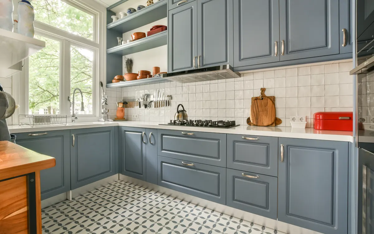 Kitchen with slate blue painted cabinets, white countertops and patterned tile floor
