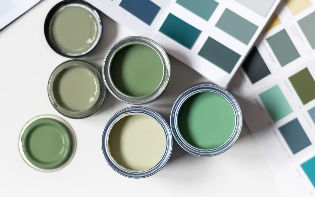 Sample paint cans and color swatch cards laid out for a color decision