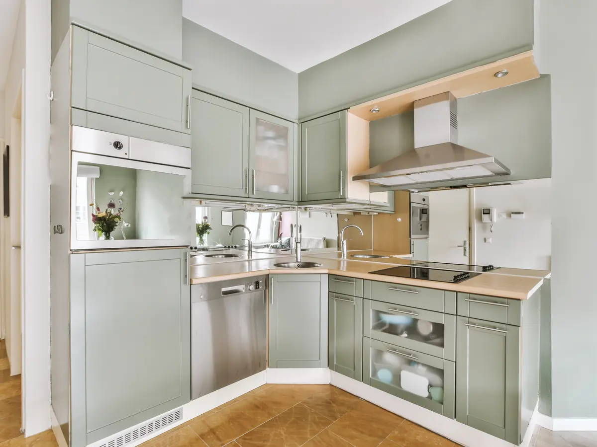 Kitchen with painted sage green cabinets and a wood floor