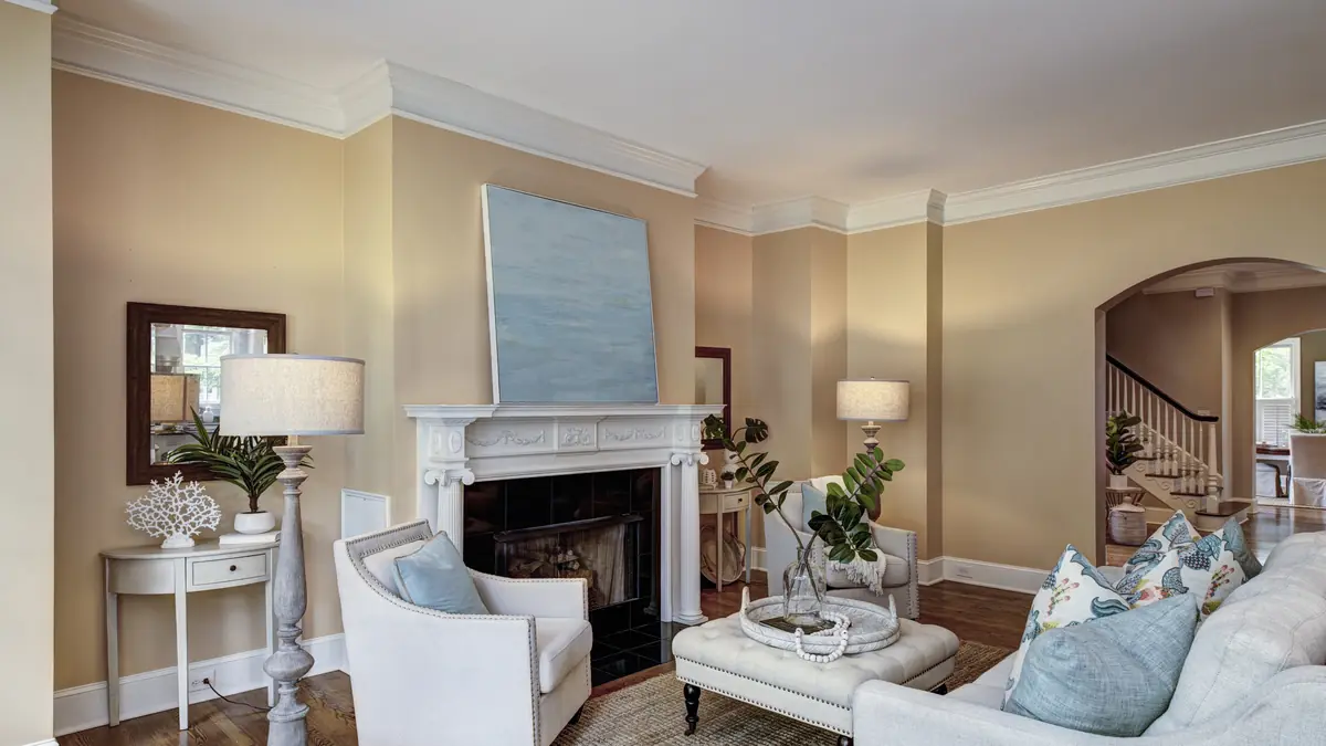 Finished living room with warm neutral walls, white trim and a fireplace in a Pearland, TX home