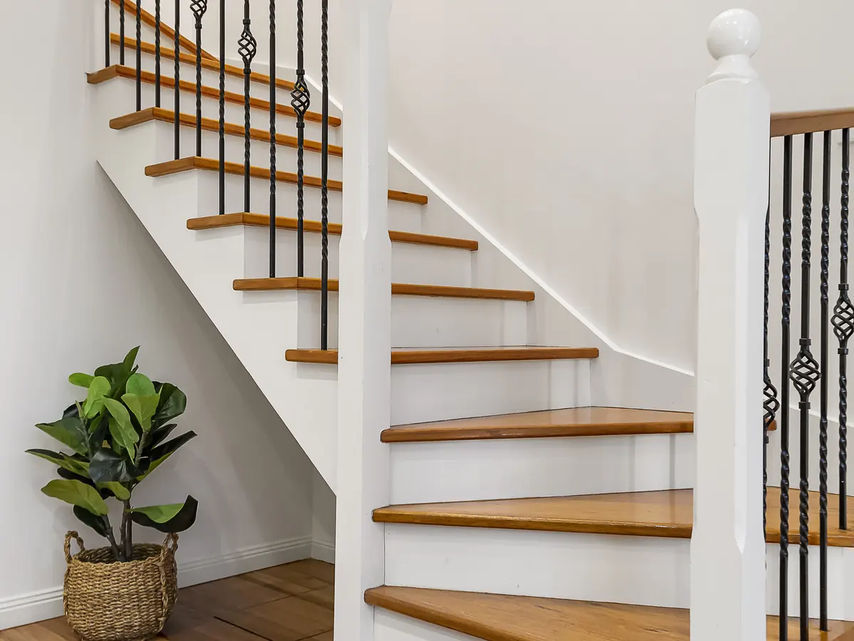 White painted staircase with oak treads and black iron balusters